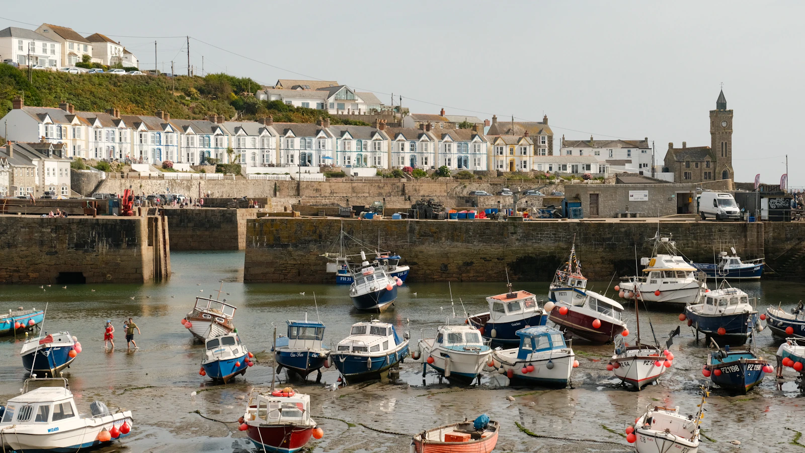 Fishing boats resting in Porthleven harbour at low tide